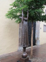 figure with both arms raised; “magic wand” in one arm