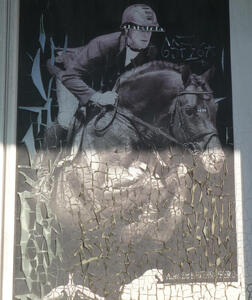 sun damaged poster of man riding horse