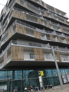 Apartment with multiple thin vertical bronze strips on balconies