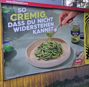 So cremig, dass du nicht widerstehen kannst. Picture of bowl of pasta with pesto flavoring. In the background is a jar of Barilla pesto.