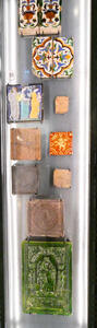 Painted ceramic tiles, some with religious themes others with geometric patterns