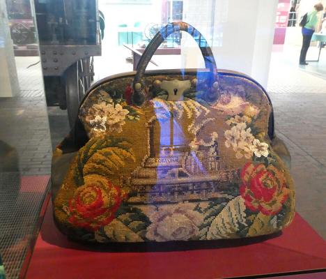 Carpet bag decorated with a train surrounded by flowers