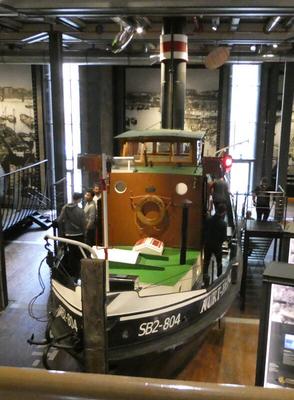 Tugboat with green deck and wood panels on cabin