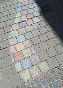 Pavement bricks colored with various colors of chalk in a winding pattern
