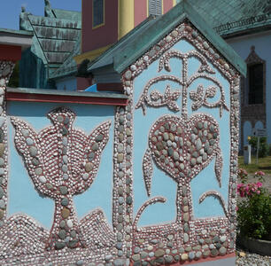 Mosaic of rounded rocks. At left, a dove. At right, a heart
