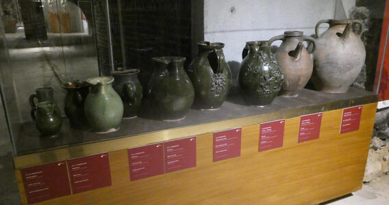 Wine jugs of various sizes. Some are green ceramic
