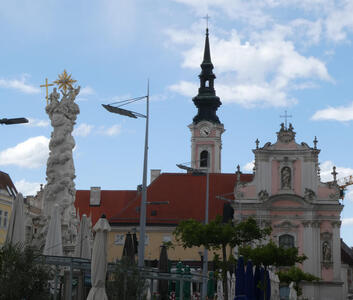 At left, Pestsäule; in middle frame, a church steeple with clock tower