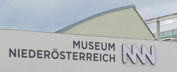 Museum name and logo. The logo looks like three connected Ns.
