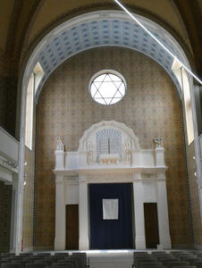 Synagogue interior showing ark for Torah and glass window above it with a star of David.