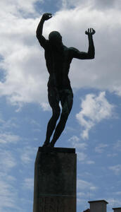 Statue of man with arms upraised and head tilted back
