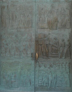 Bronze? metal door with pictures of saints and names, some of which are Hippolyt, Severin, and Florian