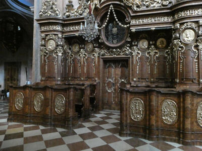 Rows of pews with metal shields on front depicting holy scenes