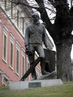 Sculpture of a painter standing, holding a folded easel
