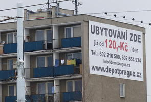 Dilapidated apartment building with advert for renting on side