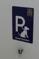 Large capital P as in Parking signs, attached to dog on leash. Text: “dog parking place”