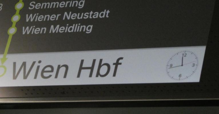 Train info display showing analog clock at lower right.