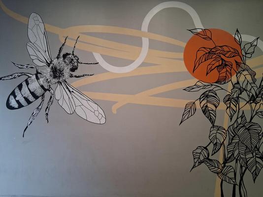 Honeybee at left, plant at right with orange circular highlight
