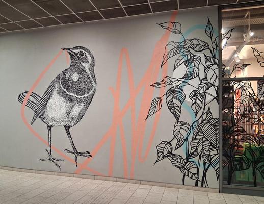 Bird with what appears to be a worm in its mouth but is actually a curved line that extends across the wall