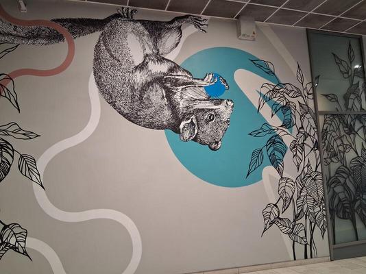 Squirrel holding a blue circle in its front paws. The painting is upside-down, as if the squirrel is hanging from the ceiling