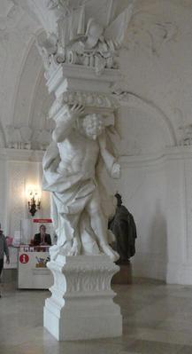 Column supported by man holding top part on his back.