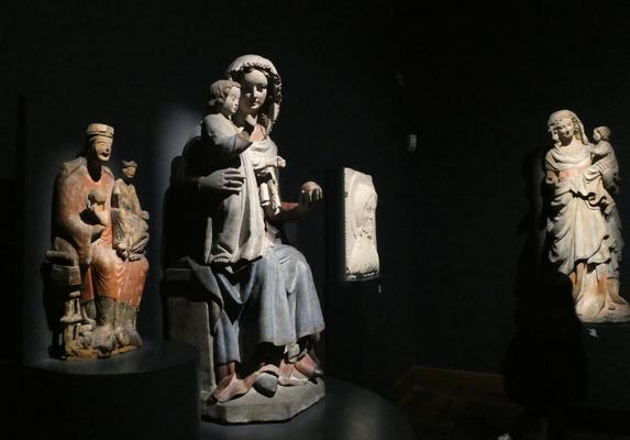 Three Madonna and Child statues from varying centuries.