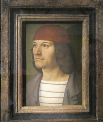 Painting of man in red hat, white shirt with horizotal brown stripes, and a gray jacket. He is shown in half-profile.