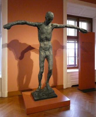 Statue of man with arms outstretched at his sides