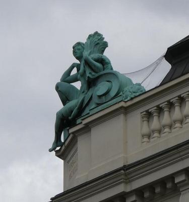 Statue of seated person on top of building