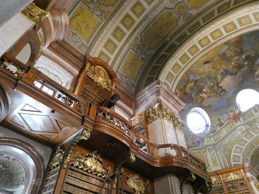 View of ceiling area with balcony, bookshelves, and arched ceiling