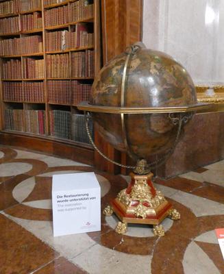 Large (1,5 m tall) old globe. Behind it, shelves of books