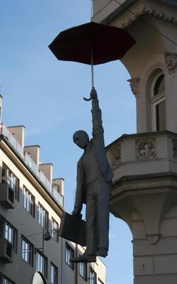 Side view of statue of man holding umbrella