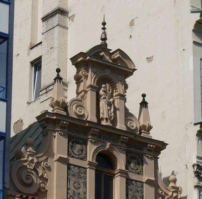 Building with niche on roof. In niche, statue of Madonna and child