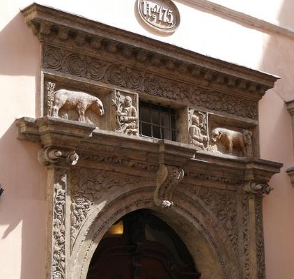 Sculpture above door of people feeding animals.