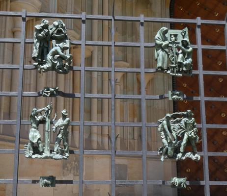 Gate with 2 by 2 array of sculptures showing various workers.