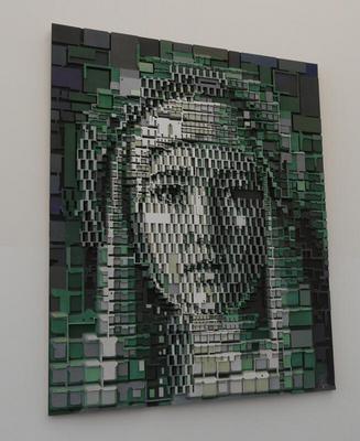 Woman’s face composed of multicolored gray green and black cubes attached to a canvas