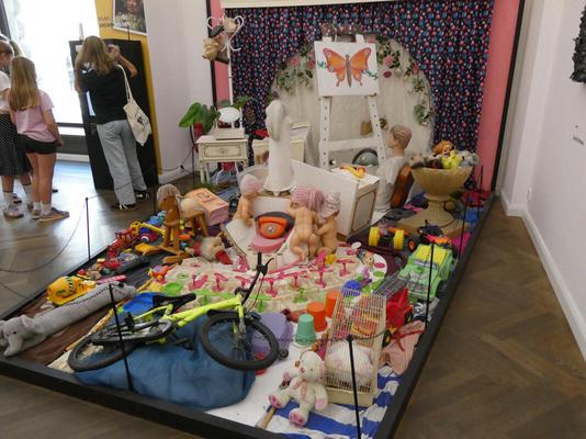 A baby’s room strewn with toys and an easel.
