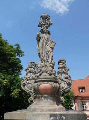 Statue of holy figure holding a book in one hand.