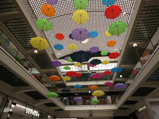 bright-colored umbrellas hanging from ceiling in a shopping center