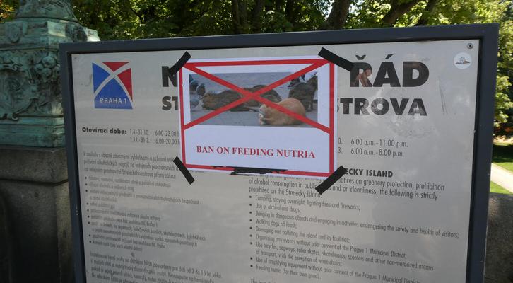Sign saying “Ban on feeding nutria” above a photo of nutria with a red X through it.